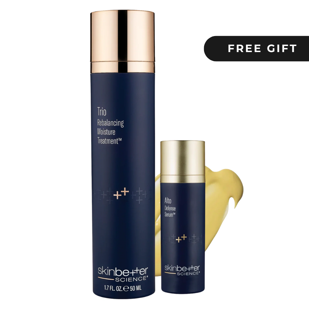 Skinbetter Science Trio Rebalancing Moisture Treatment and Ultra Defense Serum set, featuring navy blue bottles with metallic gold caps, a gold cream smear, and a black 'FREE GIFT' badge on a white background.